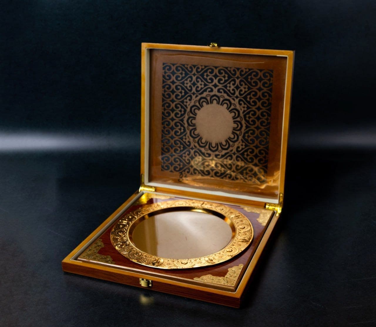 Engraved gold presentation plate seated in an open lacquered wooden case with a patterned lining