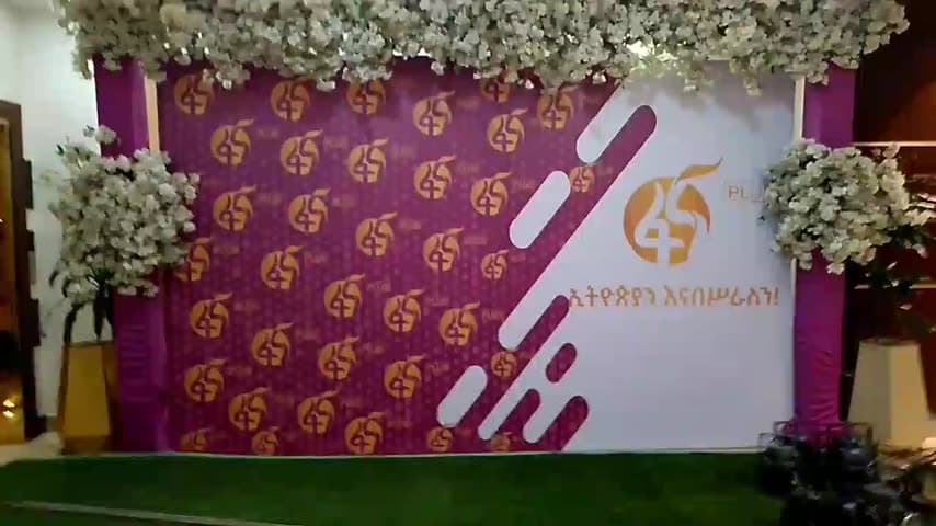 Magenta Fana 45 step-and-repeat backdrop under a white floral arch, set up for photographs