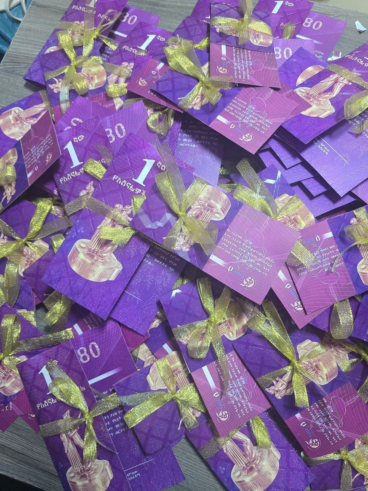 Purple and gold anniversary gala invitation cards finished with gold ribbon