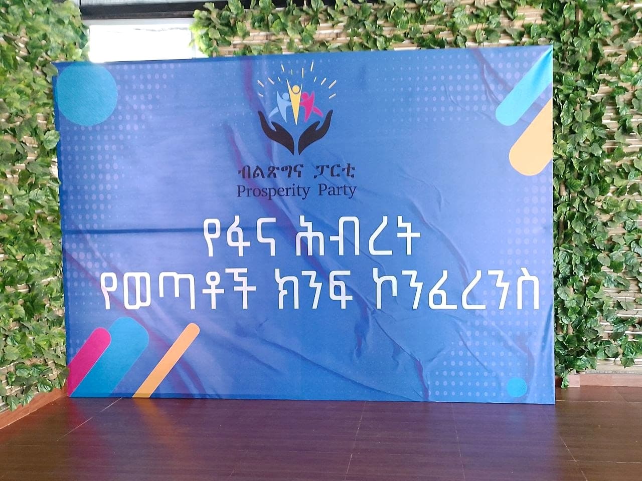 Blue conference backdrop carrying the Prosperity Party emblem and an Amharic conference title