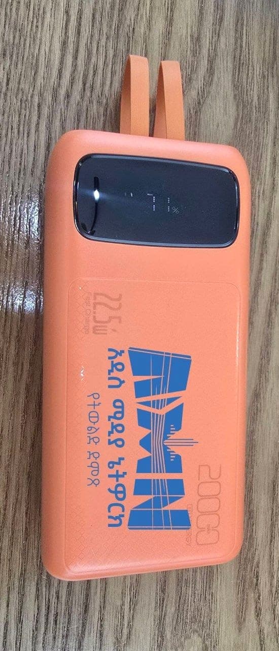 Orange 20000 mAh power bank printed with the blue Addis Media Network logo and Amharic strapline