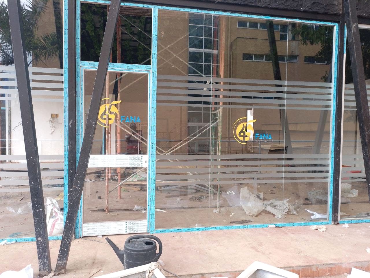 Wider view of frosted vinyl banding and the repeated Fana logo across a full glass frontage