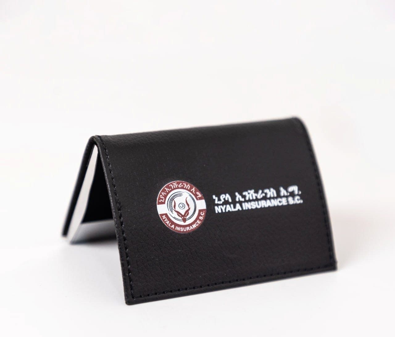 Black leather folding card wallet printed with the Nyala Insurance crest and name in Amharic and English