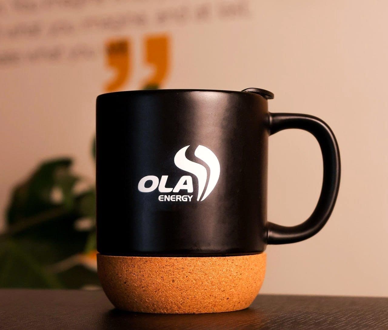 Matte black mug with a cork base and lid, printed with the white OLA Energy logo
